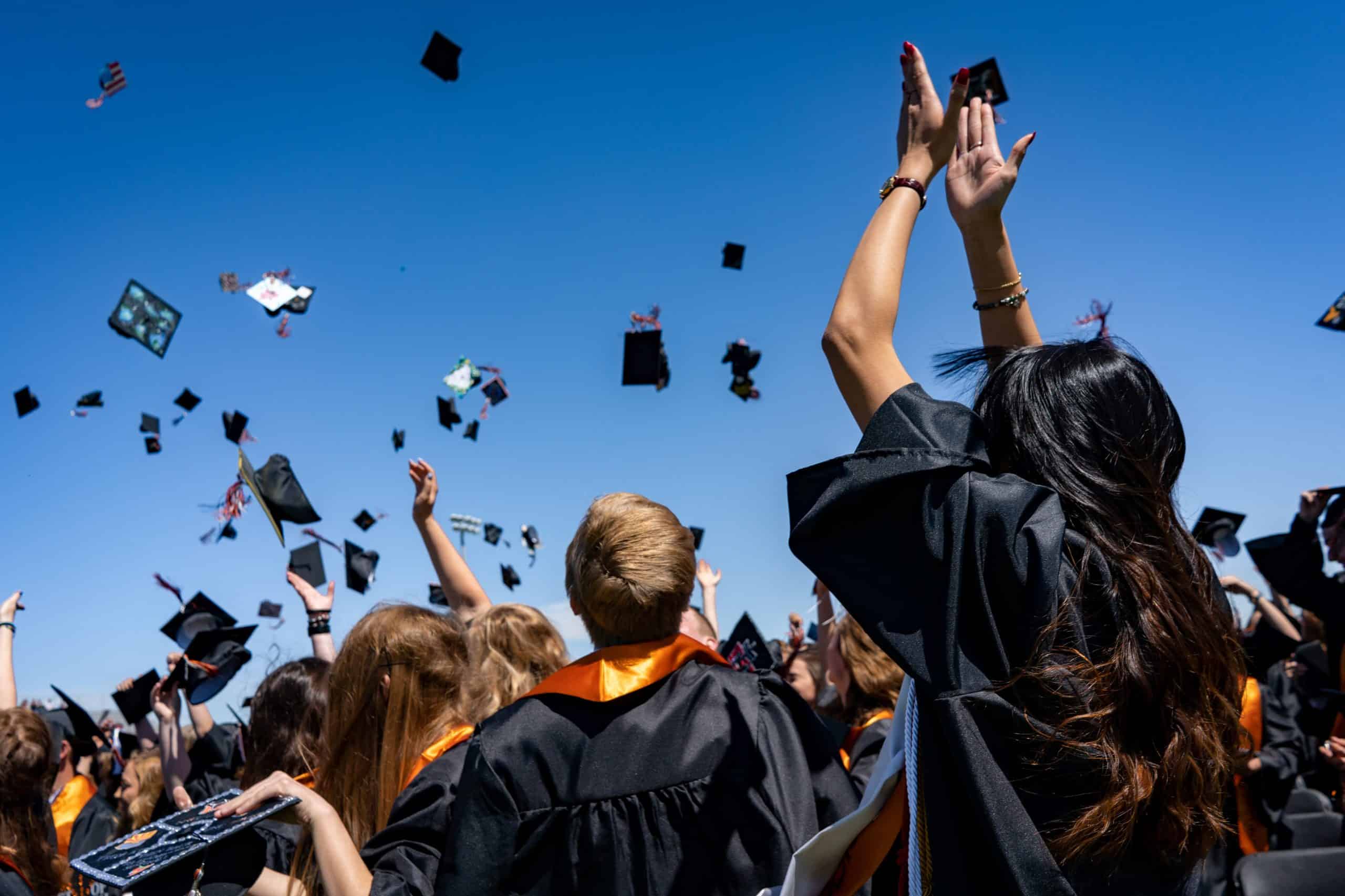 Tres graduados sentados uno al lado del otro